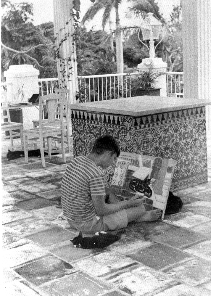 EH08499P Patrick “Mouse” Hemingway painting a kitten on the porch at Finca Vigia, San Francisco de Paula, Cuba