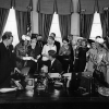President John F. Kennedy distributes pens after signing the Equal Pay Act in the Oval Office of the White House, Washington, D.C.